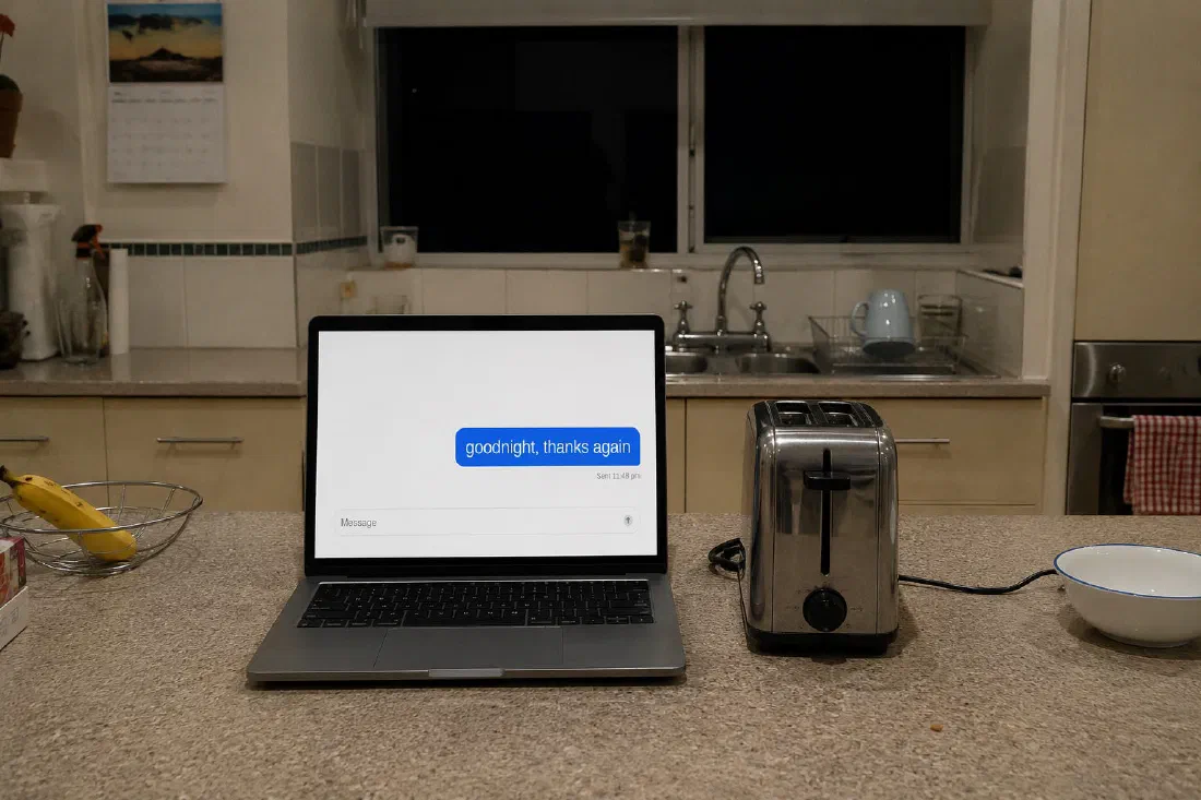 A laptop on a kitchen bench at night, next to a toaster. On screen, a single sent message: “goodnight, thanks again”, at 11:48 pm.